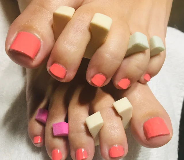 Basic pedicure with coral polish and toe separators