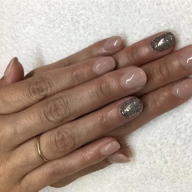 Manicure with soft nude polish and glitter accent nails
